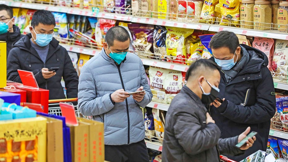 Los compradores en China usan máscaras durante la pandemia de COVID-19