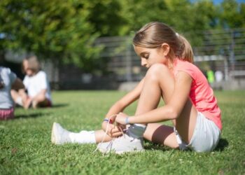 Niña atándose deportivas