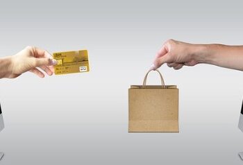 Manos surgiendo de pantallas Mac, simulando ecommerce