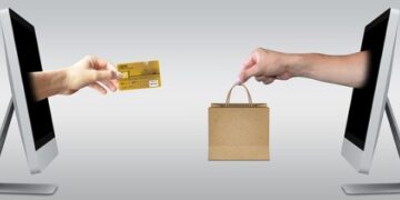 Manos surgiendo de pantallas Mac, simulando ecommerce